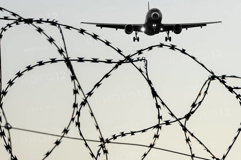 Symbolic image, deportation flights of illegal and delinquent migrants, passenger aircraft, airport, security fence, barbed wire, black and white image, Germany, Europe