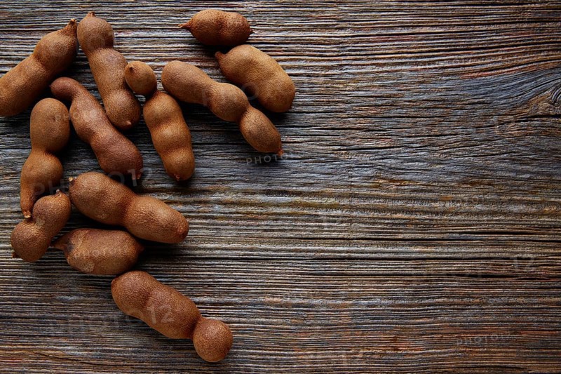 Tamarindo tamarind fruits ripe on brown wood background uses for candy