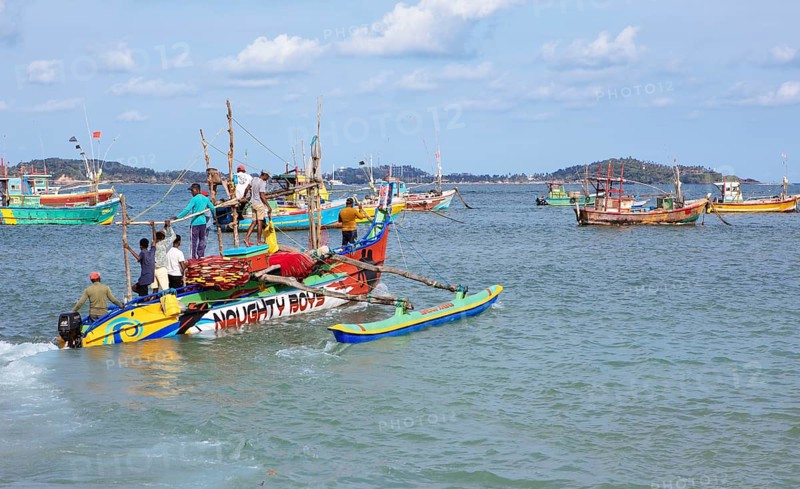 Sri Lankan fishermen on colourful outrigger boat on the Indian Ocean, Kapparatota, Matara, Southern Province, Sri Lanka, Asia