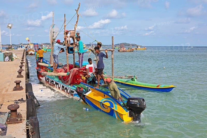 Sri Lankan fishermen on colourful outrigger boat on the Indian Ocean, Kapparatota, Matara, Southern Province, Sri Lanka, Asia