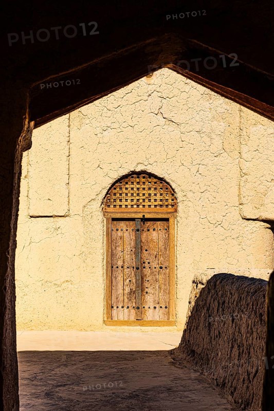 Decorated round arch entrance door in the largest preserved mud town in Oman, Al Bilaad, Al Bilaad Historical Village, Arabian Peninsula, Sultanate of Oman