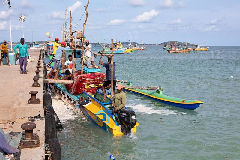 Sri Lankan fishermen on colourful outrigger boat on the Indian Ocean, Kapparatota, Matara, Southern Province, Sri Lanka, Asia