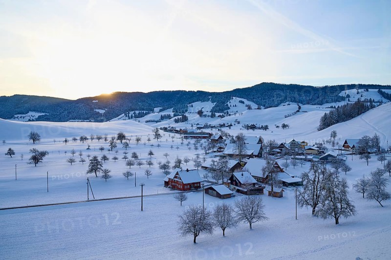 Snow-covered village in winter landscape at sunrise, surrounded by rolling hills, Menzingen, Zug, Canton Zug, Switzerland, Europe