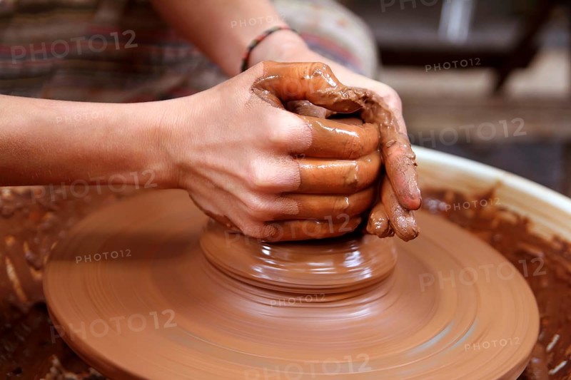 Clay potter hands closeup working on wheel handcrafts pottery work