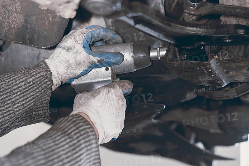 Hands of car mechanic in auto repair service