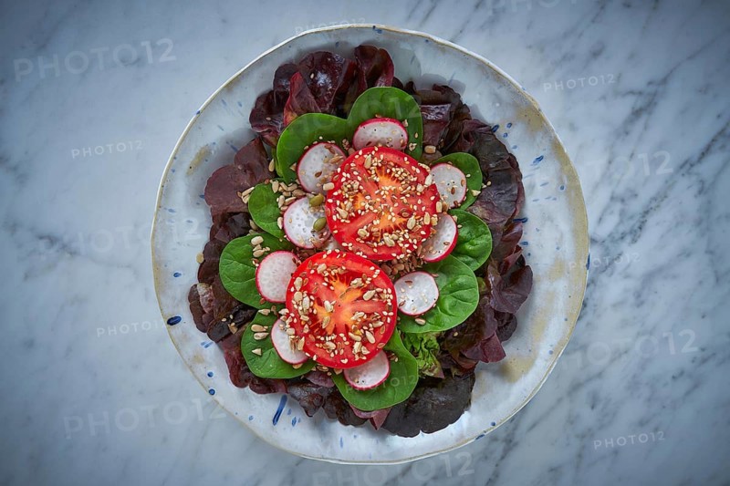 Tomato salad with seeds radish spinach and lettuces healthy food