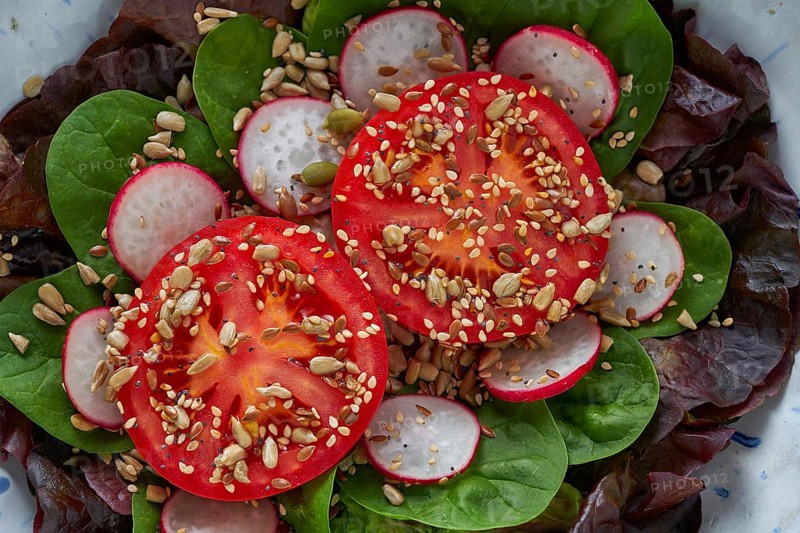 Tomato salad with seeds radish spinach and lettuces healthy food