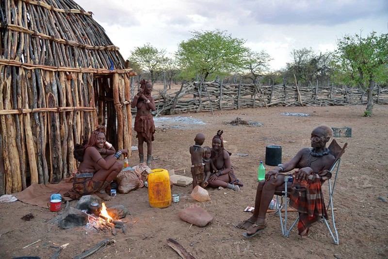 Chief Hikuminue Kapika, chief of the Namibian Himba, with his family at the fire in his kraal, Omuramba, Kaokoland, Kunene, Namibia, Africa