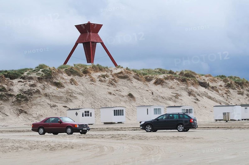 Car traffic on the beach in front of beach huts and sea mark on an early spring day in Blokhus, Jutland, Denmark, Scandinavia, Europe
