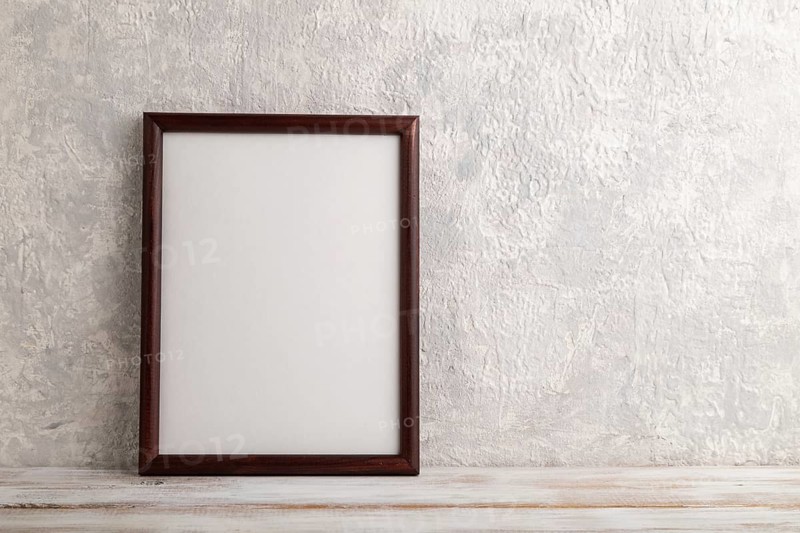 Brown wooden frame mockup on gray concrete background. Blank, vertical orientation, still life, copy space