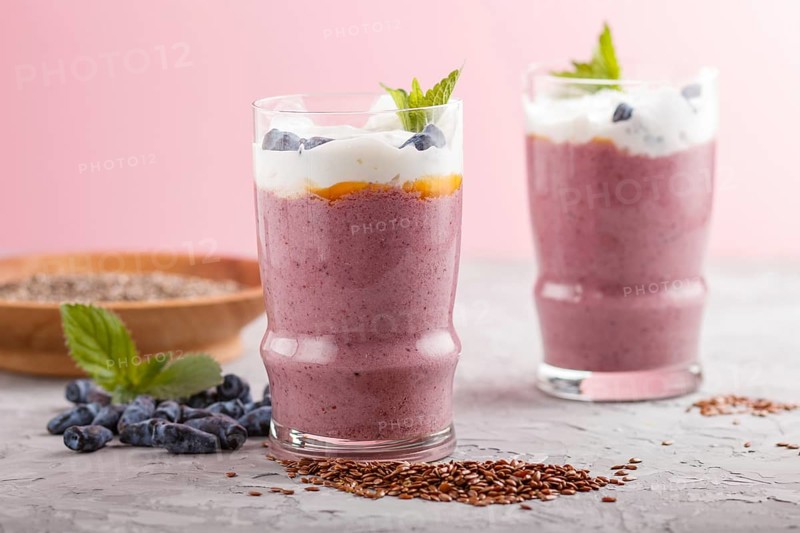 Smoothie with honeysuckle, linen and chia in a glass on gray concrete background. side view, close up, selective focus