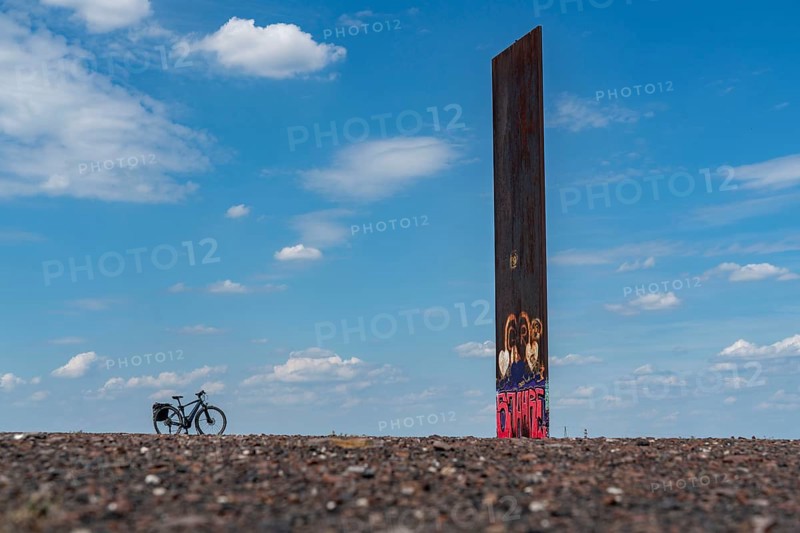 Cycling in the Ruhr area, on the Schurenbach slag heap, Bramme landmark for the Ruhr area by artist Richard Serra, Essen, North Rhine-Westphalia, Germany, Europe