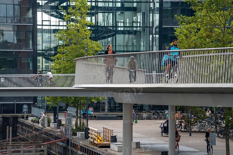 Cyclists on the Cykelslangen cycle and pedestrian bridge, at the Fisketorvet shopping centre, across the harbour, Sydhavnen, Copenhagen is considered the cycling capital of the world, 45 % of the population travel by bike, Denmark, Europe
