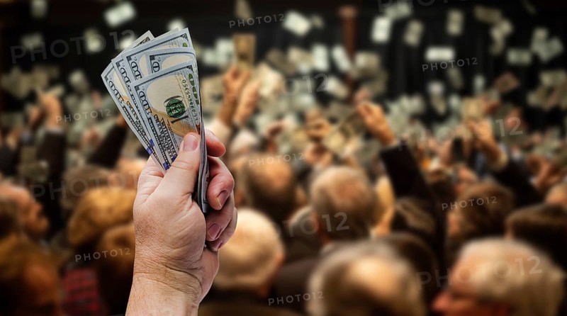 Male hand holding up 5 one hundred dollar bills at an auction. the background is generative AI., AI generated