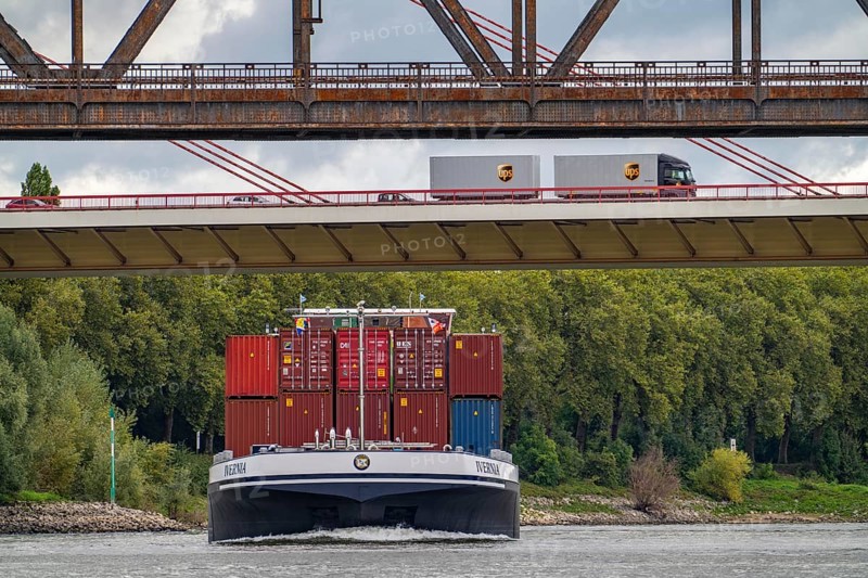 The Beeckerwerth Rhine bridge of the A42 motorway, truck traffic, in front of it the Haus-Knipp railway bridge, cargo ship on the Rhine near Duisburg, North Rhine-Westphalia, Germany, Europe