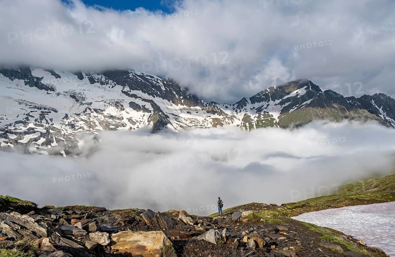 Mountaineer in front of mountain landscape with high fog in the valley, summit Hochfeiler and Hochsteller with clouds, glacier Schlegeiskees, Berliner Höhenweg, Zillertal Alps, Tyrol, Austria, Europe