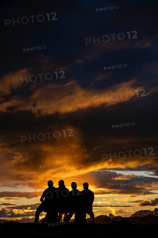 People marvelling at Montafon mountains with dramatic cloudy sky at sunset, Tschagguns, Rätikon, Montafon, Vorarlberg, Austria, Europe
