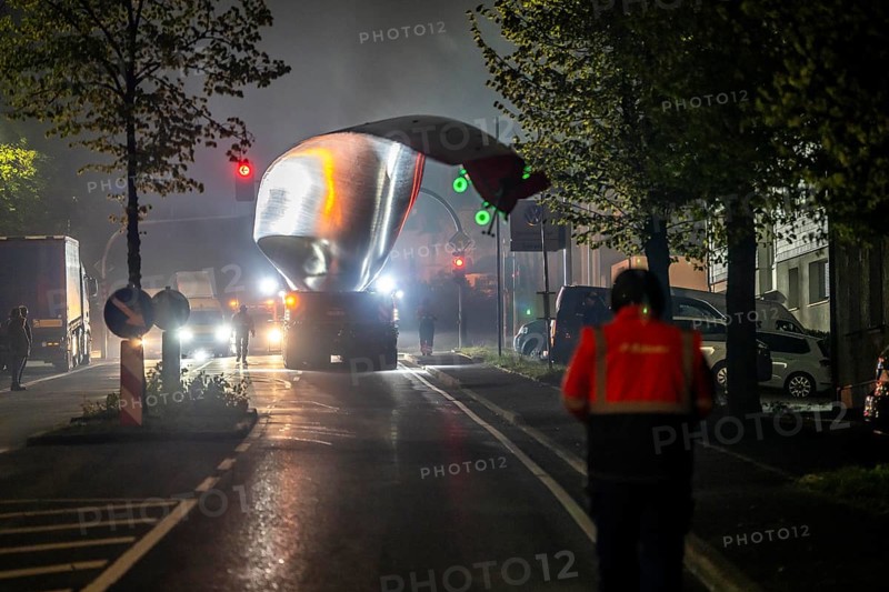 Transport of a 68 metre long, 22 tonne blade of a wind turbine, here in Breckerfeld, with a self-propelled Blade-Lifter vehicle, over a 40 km long route, over 2 nights, in the Bergisches Land, through towns, villages, over country roads, narrow through roads, to the construction site of the wind turbine near Hagen, North Rhine-Westphalia, Germany, Europe