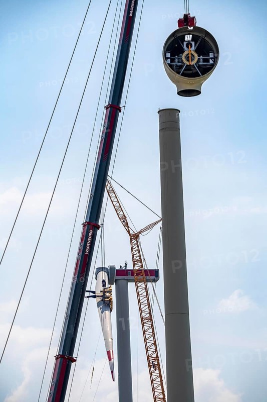 Erection of an Enercon E-160 wind turbine, rear, assembly of the first blade, 4 turbines with a total output of 22 megawatts replace 9 older wind turbines from the manufacturer Enercon (model series E-58) in the wind farm near Issum, front, dismantling of the nacelle, they were in operation for over two decades, Lower Rhine, North Rhine-Westphalia, Germany, Europe