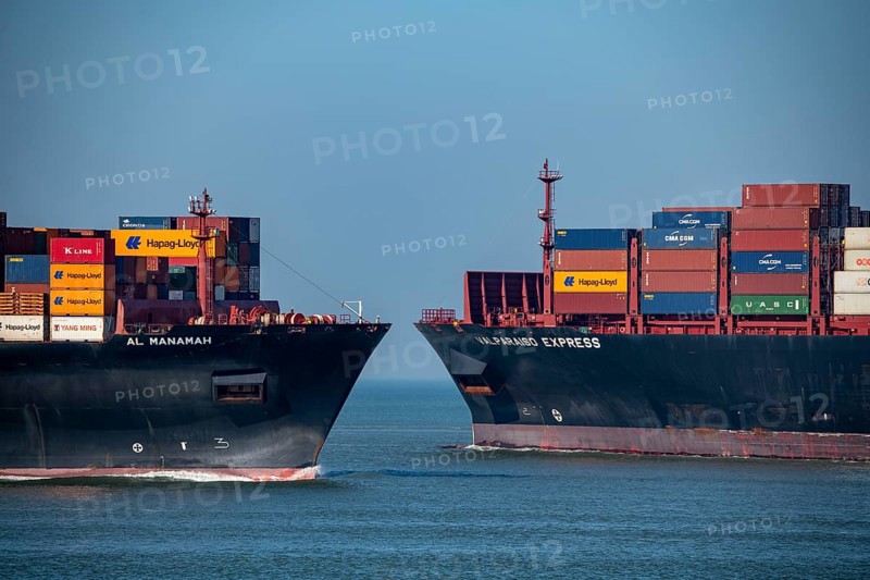 Container freighter Al Manamah, owned by Hapag-Lloyd, and VALPARAISO EXPRESS, leaving the harbour entrance of the deep-sea port Maasvlakte 2, the seaport of Rotterdam, Netherlands, on an artificial land area off the original coastline