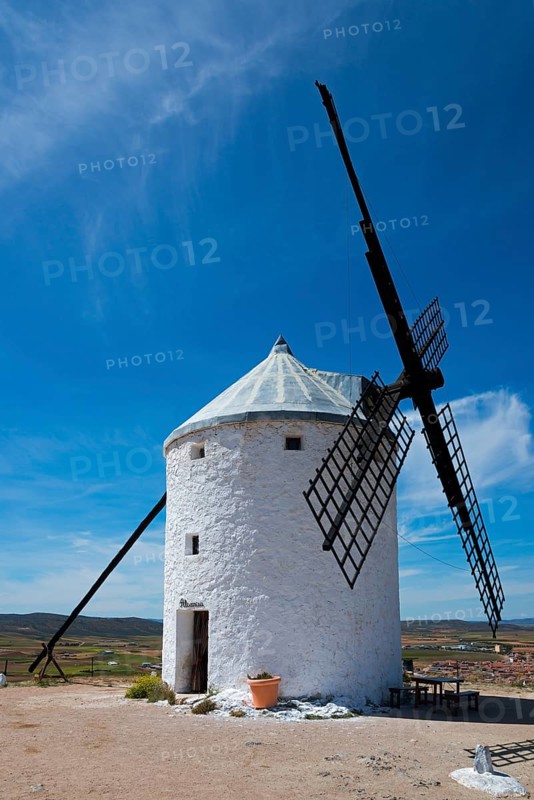 White windmill in a rural landscape under a blue sky on a sunny day with some clouds, Consuegra, Toledo, Castilla-La Mancha, Route of Don Quixote, Spain, Europe