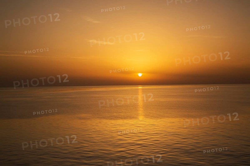 Setting golden sun over Adriatic sea taken from the top deck of a cruise ship in late summer, near Zadar, Croatia, Europe