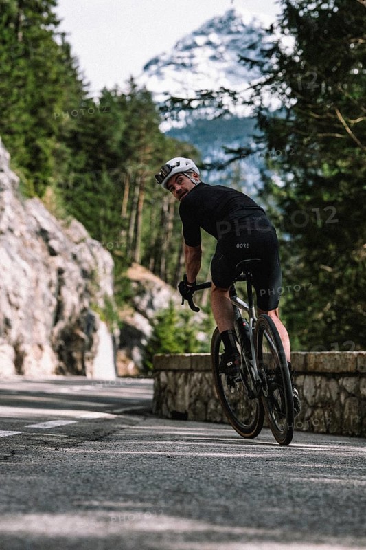 Road bike rider in spring between Lechtal and Tannheimer Tal in front of picturesque scenery of the Alps, Tyrol, Austria, Europe
