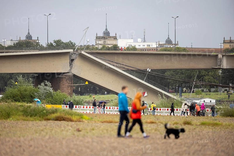 Passers-by look at the partially collapsed Carola Bridge from the Königsufer in Dresden, 11/09/2024