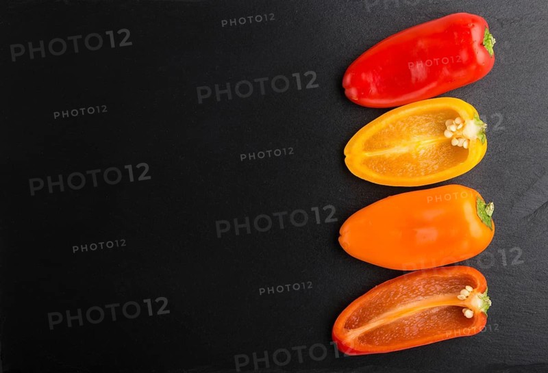 Yellow, red, orange sweet peppers on a black slate background. top view, copy space, flat lay, close up