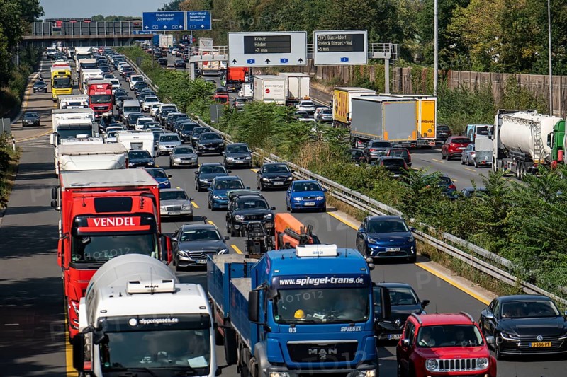 Traffic jam on the A3 motorway, over 8 lanes, in both directions, in front of the Leverkusen motorway junction, Friday afternoon high traffic volume, roadworks, gantry signs with journey times, delays due to the traffic jam, Leverkusen, North Rhine-Westphalia, Germany, Europe