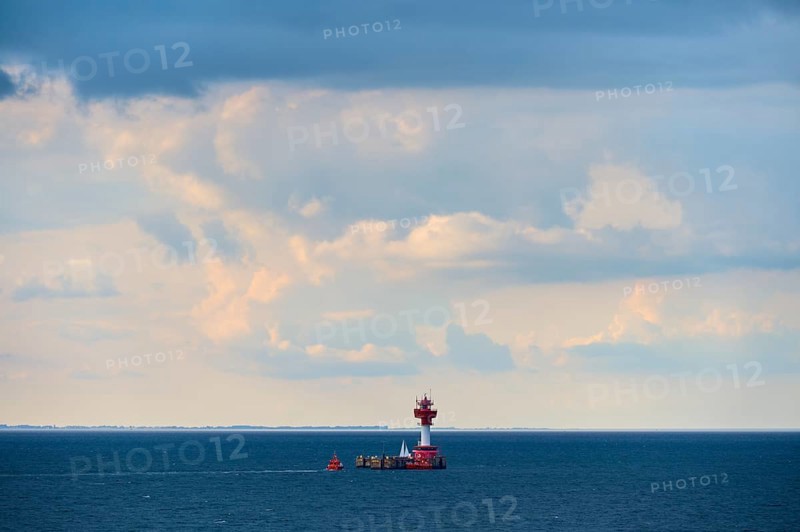 A red lighthouse stands on a calm, blue sea under a slightly cloudy sky, with a pilot boat, lighthouse Kiel, pilot station, Kiel, Schleswig-Holstein, North Sea, Germany, Europe