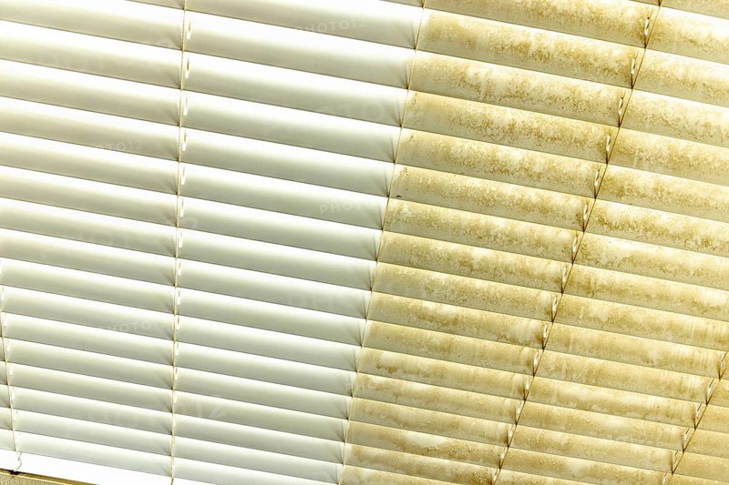 Residential window shades showing the before and after of a good cleaning, one side clean and one side dirty