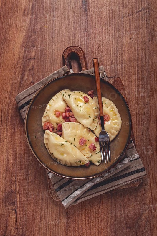 Dumplings, with fried prosciutto, a traditional dish of Polish cuisine, dumplings, top view, close-up, without people