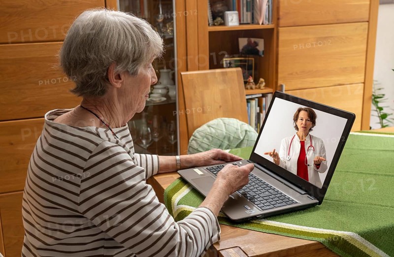 Symbolic image of telemedicine, patient speaking to a doctor in a video conference from home