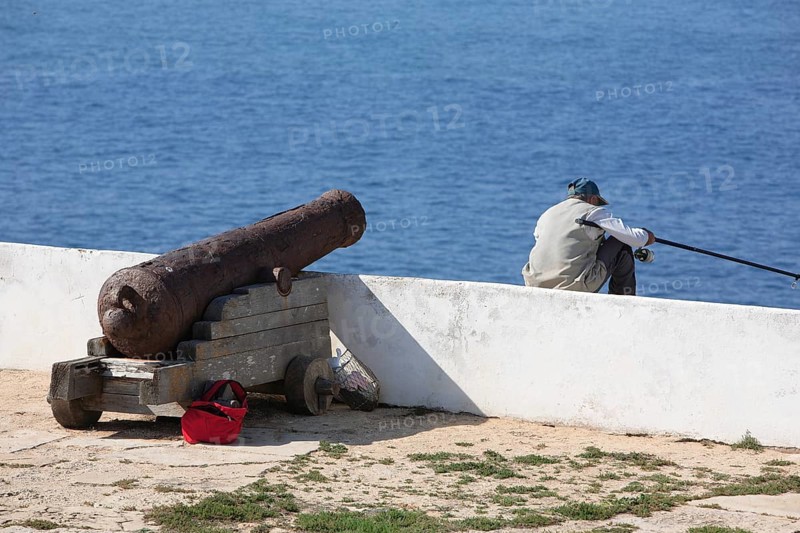 Cliff fishermen and historic cannon in the Fortaleza de Sagres, Vila do Infante, Sagres, Algarve, Portugal, Europe