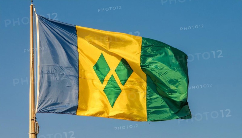 The flag of the Grenadines flutters in the wind, isolated against a blue sky