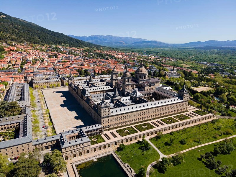 Aerial view of a historic monastery and town with mountains in the background on a sunny day, aerial view, Real Sitio de San Lorenzo de El Escorial, Royal Seat of St Lawrence of El Escorial, palace and monastery complex, San Lorenzo de El Escorial, Madrid, Spain, UNESCO World Heritage Site, Europe