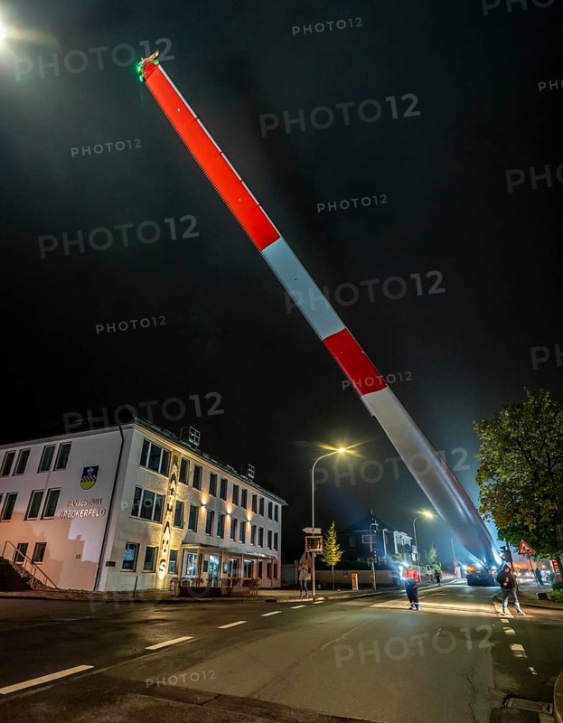 Transport of a 68 metre long, 22 tonne blade of a wind turbine, here in Breckerfeld, with a self-propelled Blade-Lifter vehicle, over a 40 km long route, over 2 nights, in the Bergisches Land, through towns, villages, over country roads, narrow through roads, to the construction site of the wind turbine near Hagen, North Rhine-Westphalia, Germany, Europe