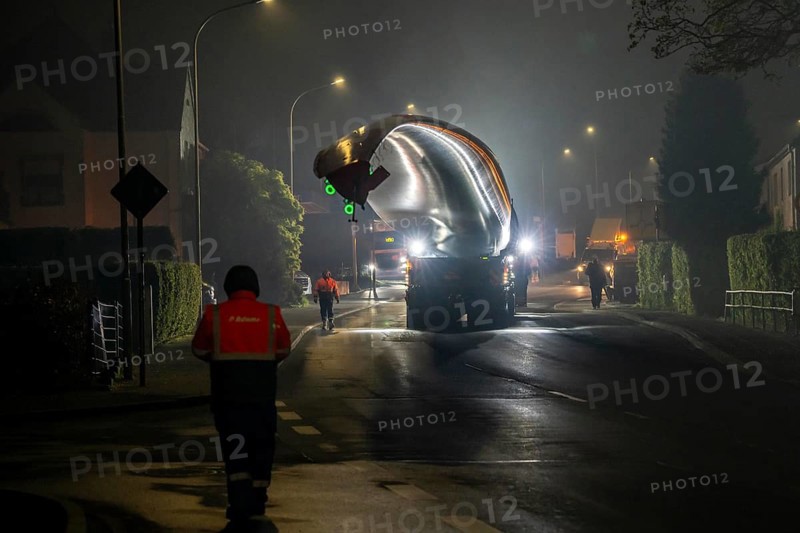 Transport of a 68 metre long, 22 tonne blade of a wind turbine, here in Breckerfeld, with a self-propelled Blade-Lifter vehicle, over a 40 km long route, over 2 nights, in the Bergisches Land, through towns, villages, over country roads, narrow through roads, to the construction site of the wind turbine near Hagen, North Rhine-Westphalia, Germany, Europe