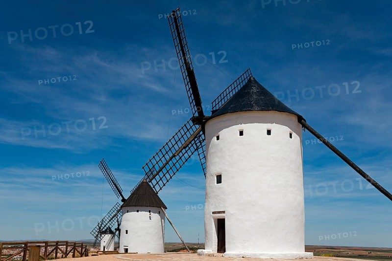 White windmills against a bright blue sky in a rural landscape on a sunny day, Alcazar de San Juan, Ciudad Real, Castilla-La Mancha, Route of Don Quixote, Spain, Europe