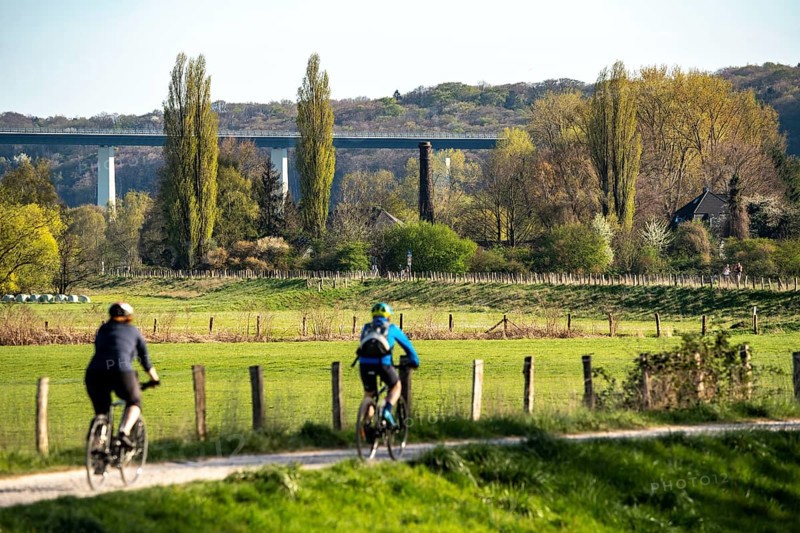 Landscape near Mülheim an der Ruhr, fields in spring, Ruhr dyke, part of the Ruhr valley cycle path, cyclists, Ruhr valley bridge, Germany, Europe