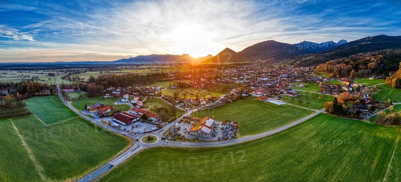 Aerial view of a village in an expansive landscape at sunset, surrounded by mountains, Bad Feilnbach