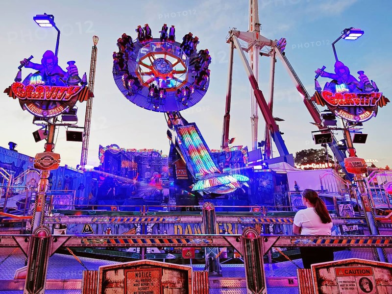 People on the illuminated carousel Mr Gravity in the evening, Cranger Kirmes, Herne, Ruhr area, North Rhine-Westphalia, Germany, Europe