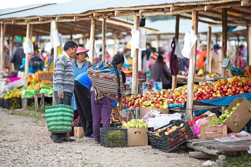 Peruvian family buys fruit at the Indio market in Chinchero, Cusco region, Peru, South America