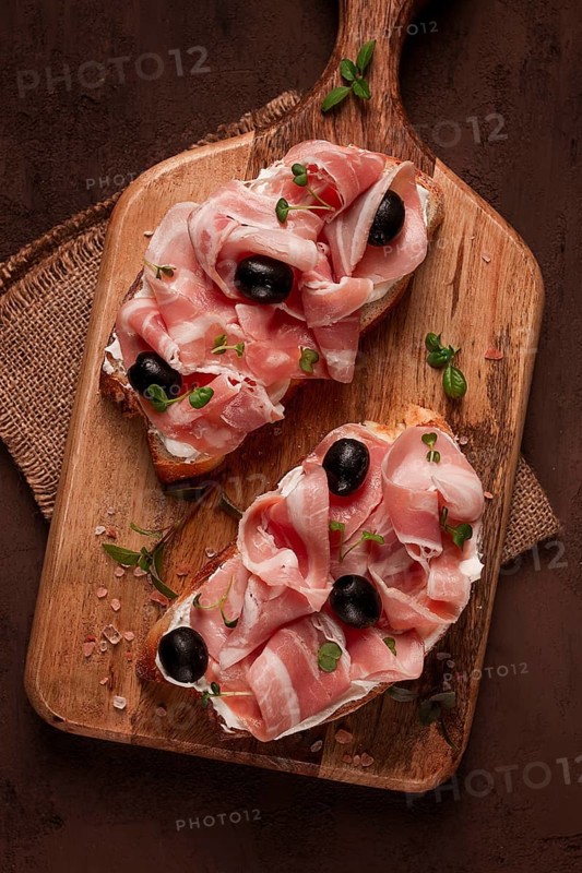 Breakfast, bacon and olives sandwich, on a cutting board, top view, close-up, no people