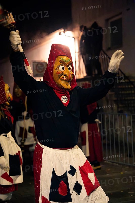 Fool figure with torch in hand celebrates carnival at night, carnival, Schellbronn night procession, Schellbronn, Germany, Europe