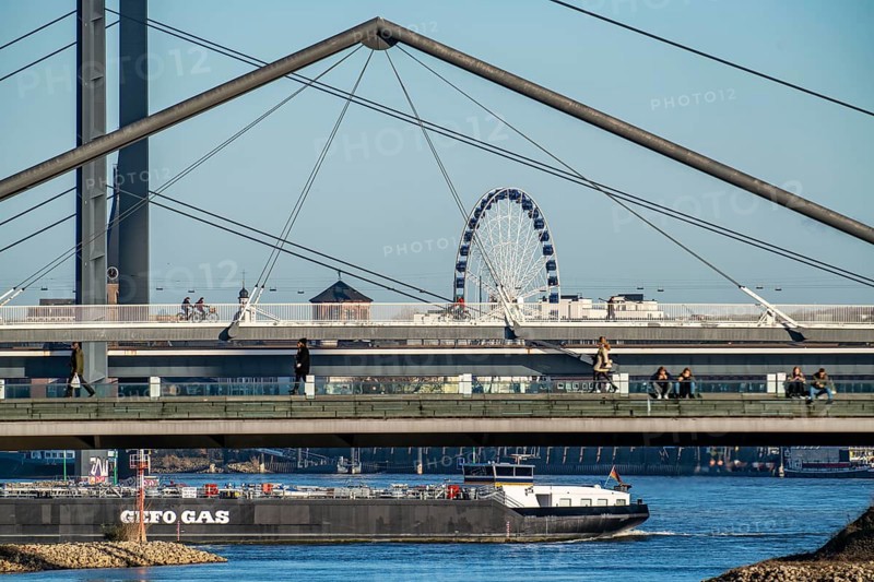 Pedestrian bridge over the Media Harbour, Ferris wheel in the old town, cargo ship on the Rhine, harbour entrance and Rhine knee bridge, over the Rhine near Düsseldorf, Rhineland, North Rhine-Westphalia, Germany, Europe