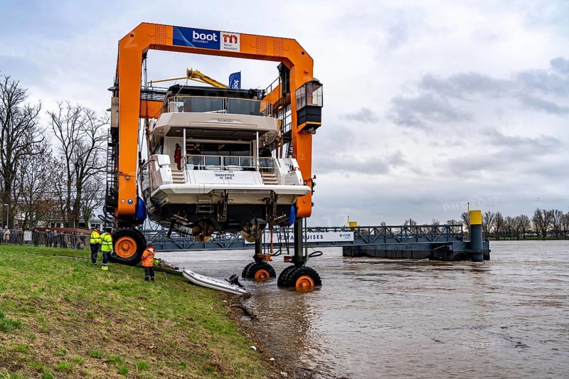 Craning the €6.3 million Sunseeker 88Y motor yacht, weighing 82 tonnes, in preparation for the world's largest water sports trade fair, Boot in Düsseldorf, luxury yachts are driven across the Rhine to the trade fair and brought ashore with the help of the Big Willi ship crane and transported to the exhibition halls on a low-loader, North Rhine-Westphalia, Germany, Europe