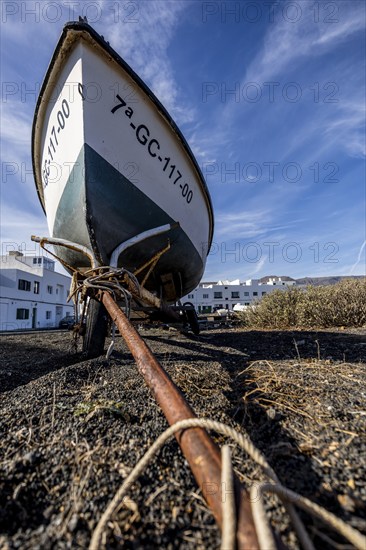 Close-up of a boat on the beach with rope and blue sky in the background, Canary Islands, Lanzarote, Spain, Europe