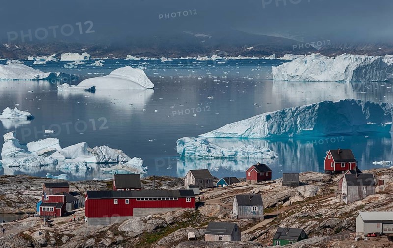 Large icebergs floating in fjord behind Inuit settlement Tiniteqilaaq, Sermilik Fjord, East Greenland, Greenland, North America